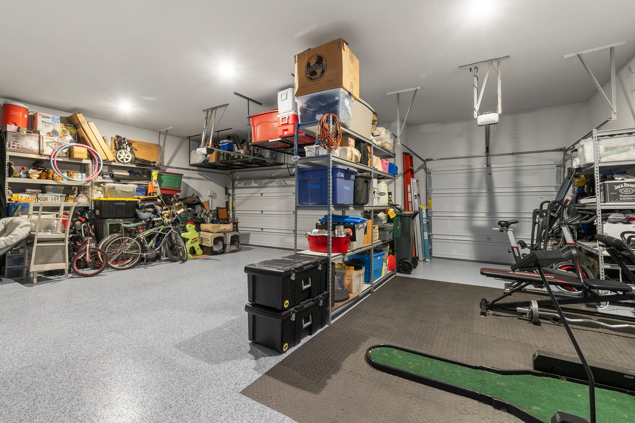 460 Constitution Way Kyle, TX 78640 - Photo 32 of 40 Spacious garage featuring a durable epoxy-coated concrete floor, recessed ceiling lighting, two overhead garage doors, and built-in shelving systems
