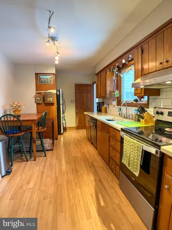 a large kitchen with stainless steel appliances kitchen island granite countertop a large window and cabinets