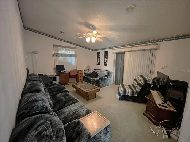 a living room with furniture a air conditioner vent and a window