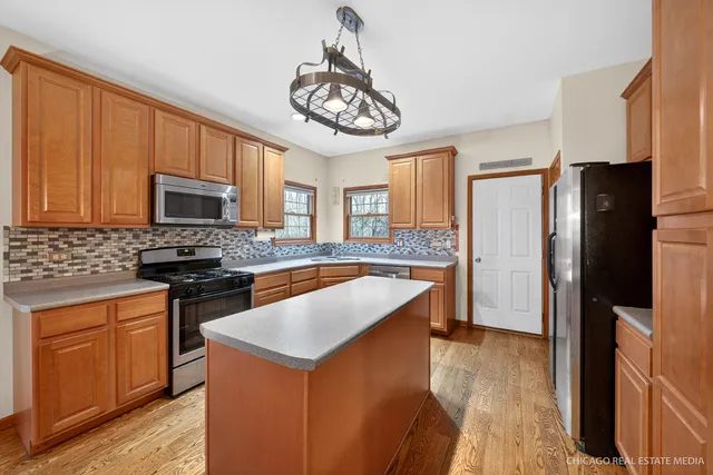 a kitchen with stainless steel appliances granite countertop a refrigerator a stove top oven a sink and dishwasher