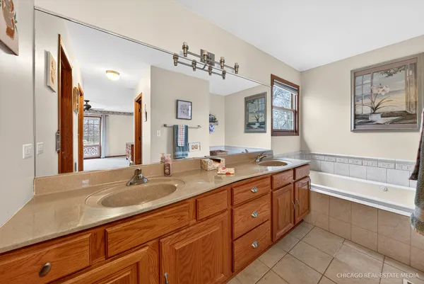 a spacious bathroom with a tub sink and mirror