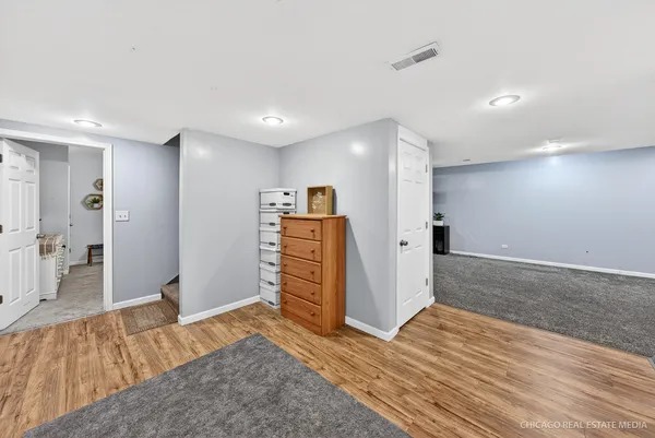 a spacious bedroom with a bed and a dresser