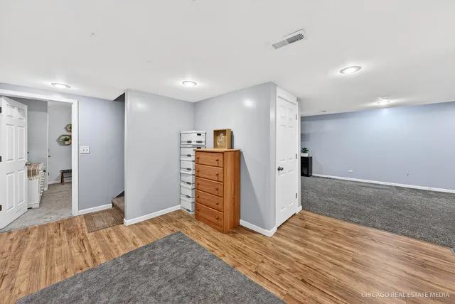 a spacious bedroom with a bed and a dresser