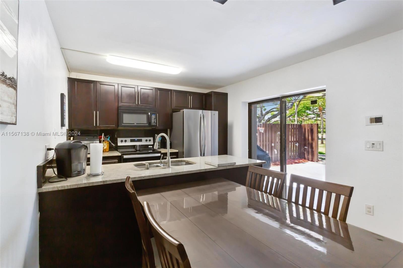 8379 Boca Rio Drive Boca Raton, FL 33433 - Photo 6 of 30 a kitchen with kitchen island a stove a sink and a refrigerator