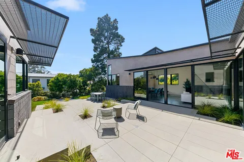 a view of a patio with table and chairs and potted plants