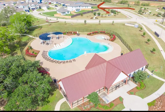 an aerial view of a house a yard and lake