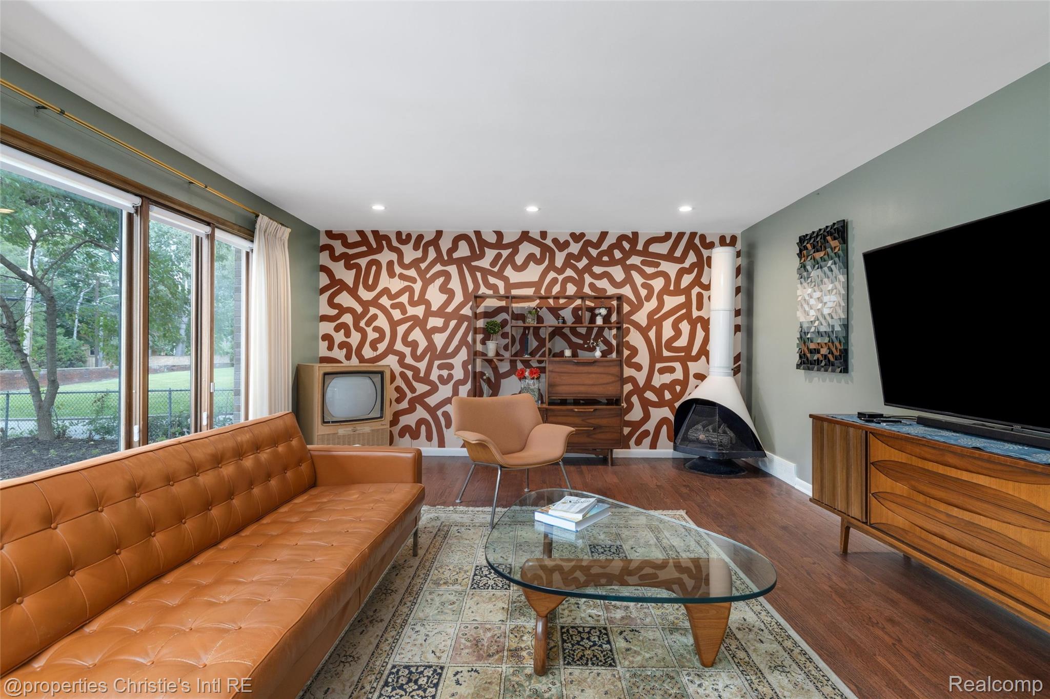2771 West Seven Mile Road Detroit, MI 48221 - Photo 22 of 57 Living area featuring wood-finish flooring, a patterned accent wall, recessed lighting, and a freestanding fireplace
