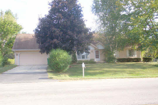 6449 Rendova Court Roscoe, IL 61073 - Photo 1 of 6 a view of a house with a large tree and a yard