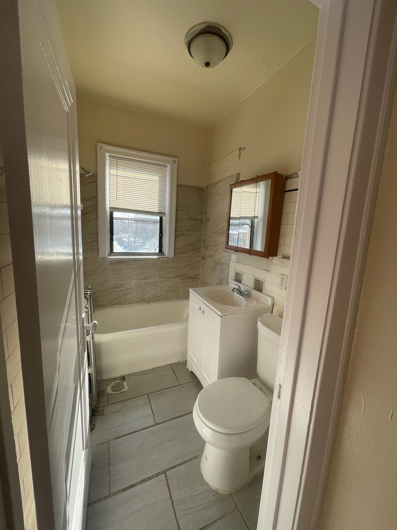117 East 68th Street, Unit 3 Chicago, IL 60637 - Photo 11 of 17 a bathroom with a toilet a sink and a bathtub