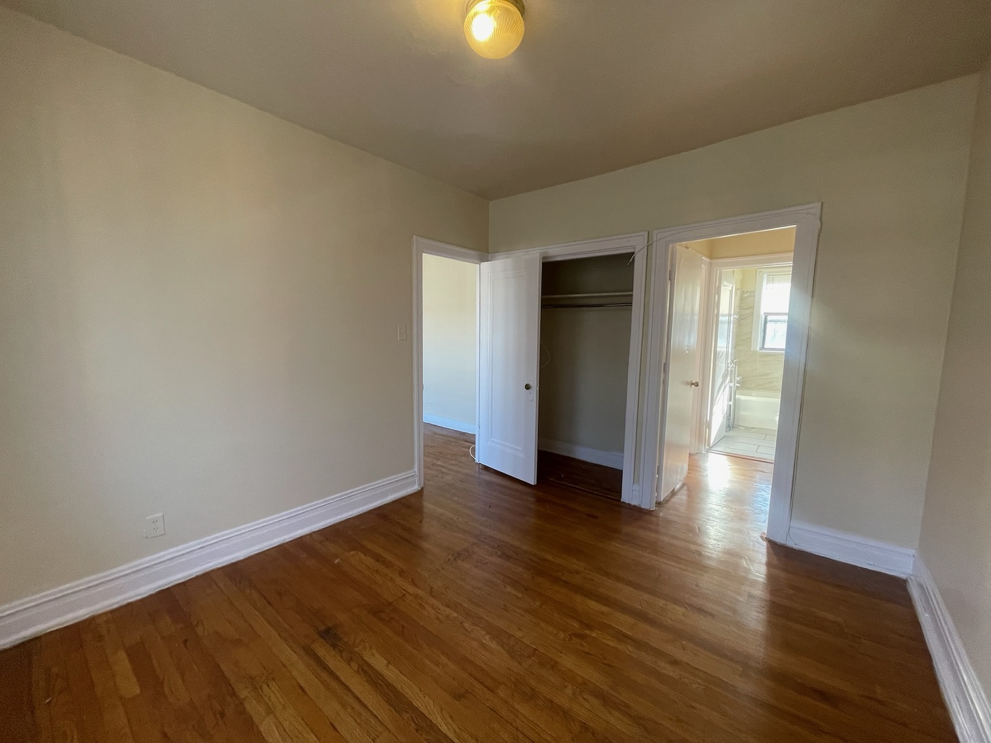 117 East 68th Street, Unit 3 Chicago, IL 60637 - Photo 13 of 17 a view of an empty room with wooden floor and a window
