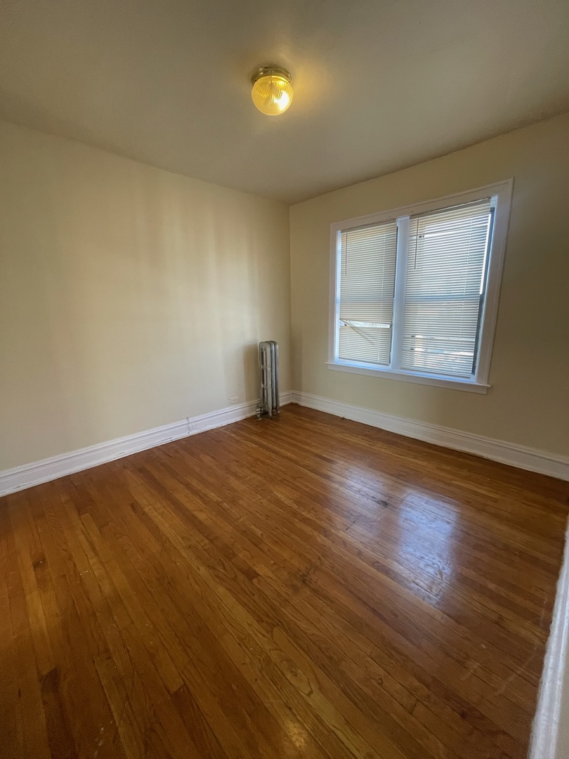 117 East 68th Street, Unit 3 Chicago, IL 60637 - Photo 14 of 17 a view of an empty room with wooden floor and a window