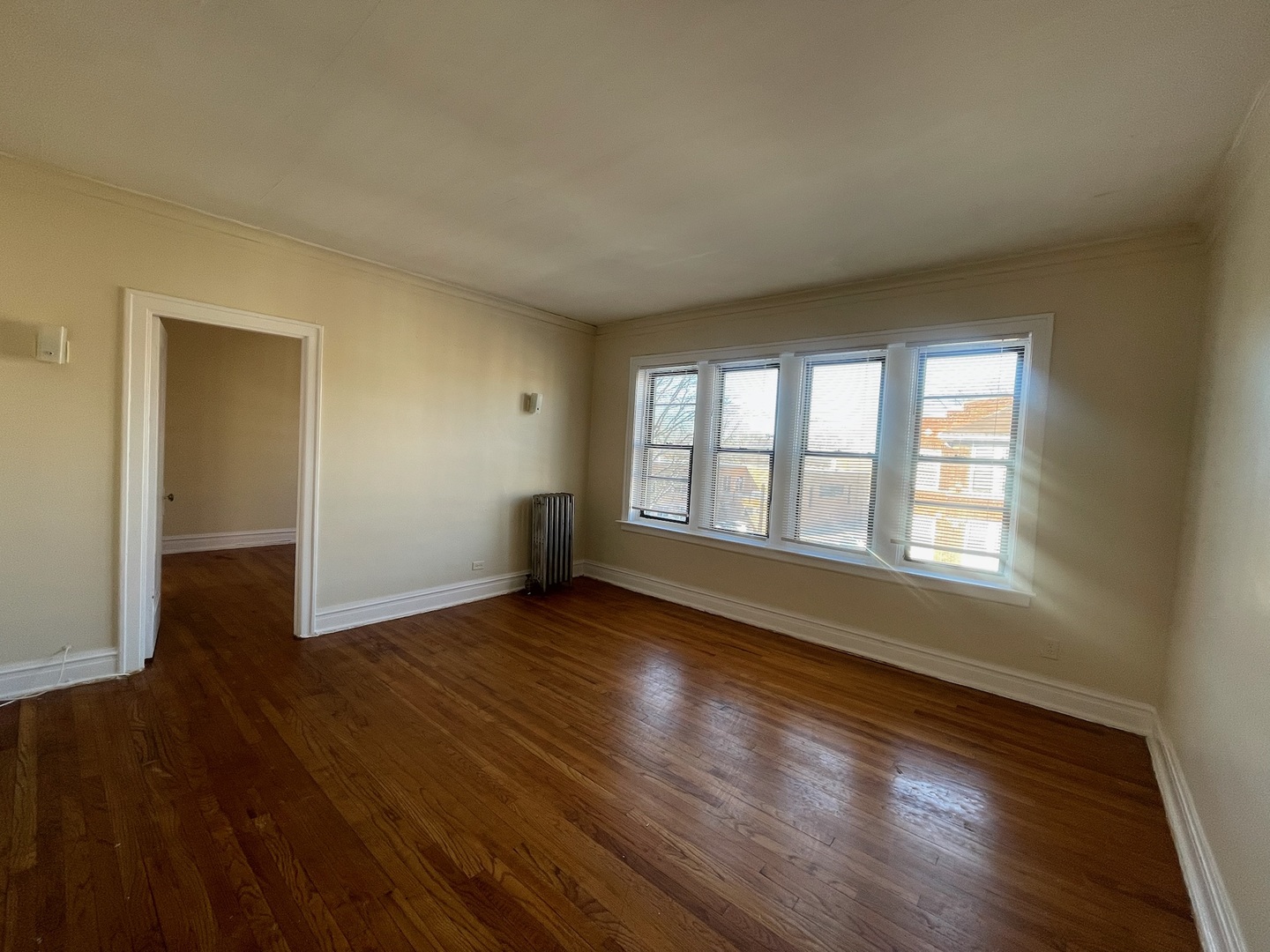 117 East 68th Street, Unit 3 Chicago, IL 60637 - Photo 16 of 17 a view of an empty room with wooden floor and a window