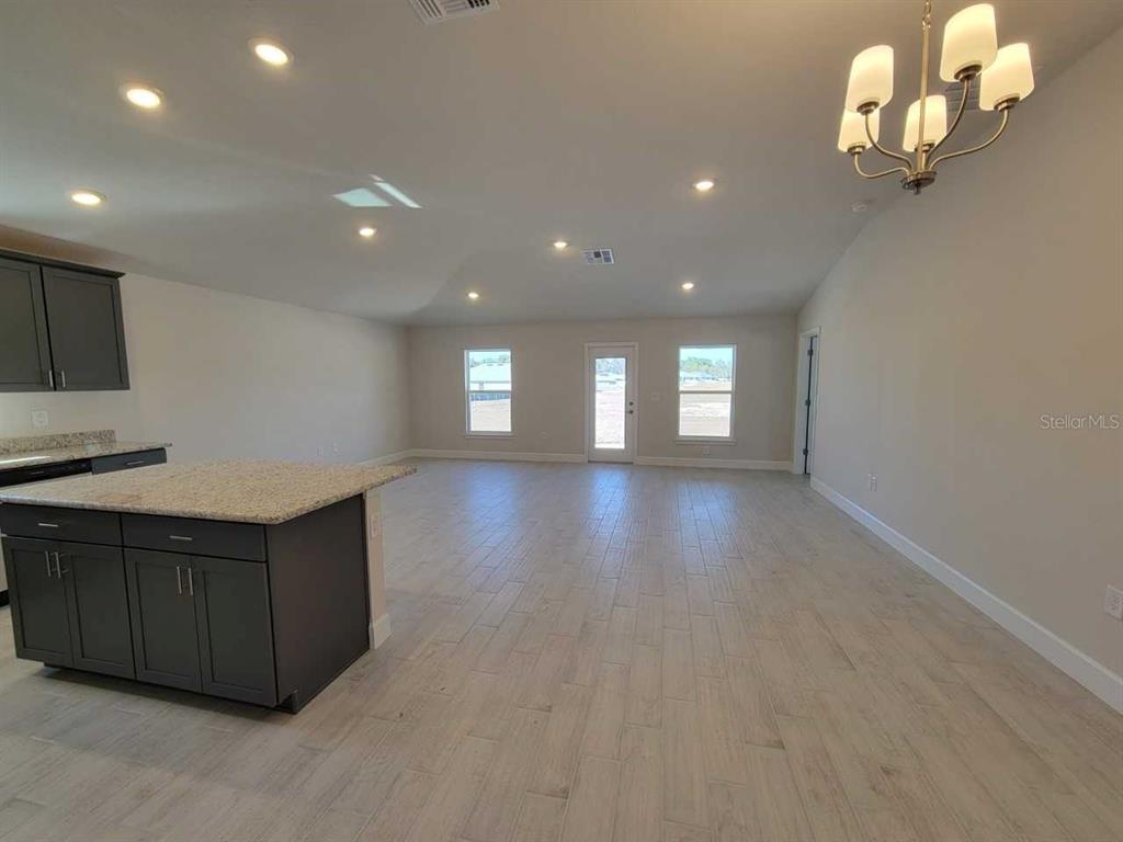 4537 Southwest 91st Ln Road Ocala, FL 34476 - Photo 6 of 18 a view of a room with wooden floor and chandelier