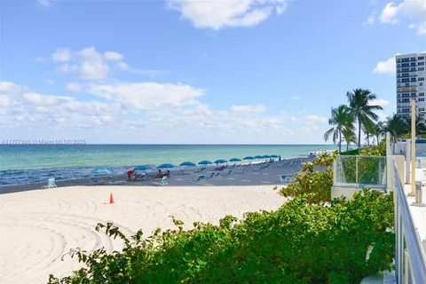 a view of a patio with couches table and chairs with potted plants and palm trees