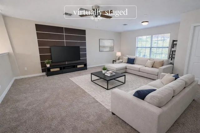 a living room with furniture a flat screen tv and a window