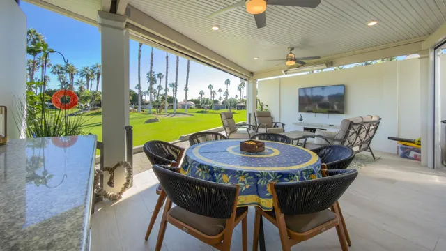 a view of a dining room with furniture one side kitchen view and wooden floor