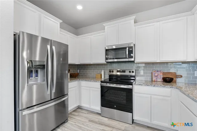 a kitchen with stainless steel appliances a refrigerator stove and microwave