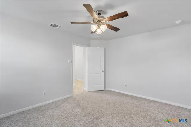 an empty room with closet and ceiling fan