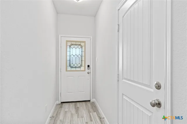 a view of a hallway with wooden floor