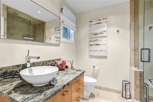a bathroom with a granite countertop sink toilet and shower