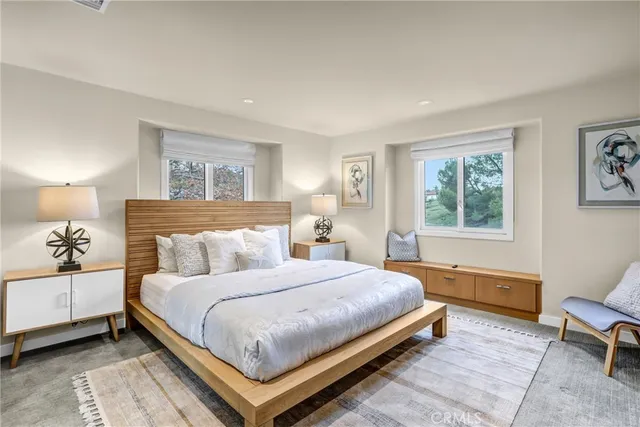 front view of a brick house with a large window and potted plants
