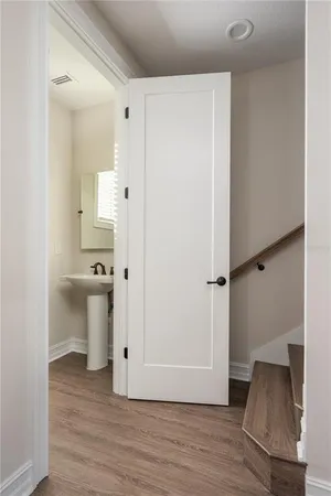a view of a hallway with wooden floor and cabinet