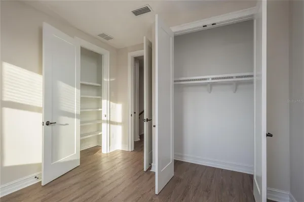 a view of empty room with wooden floor