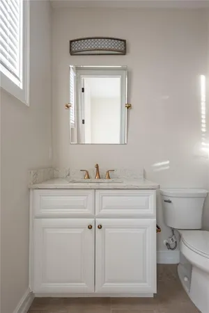 a bathroom with a toilet a sink a vanity and mirror