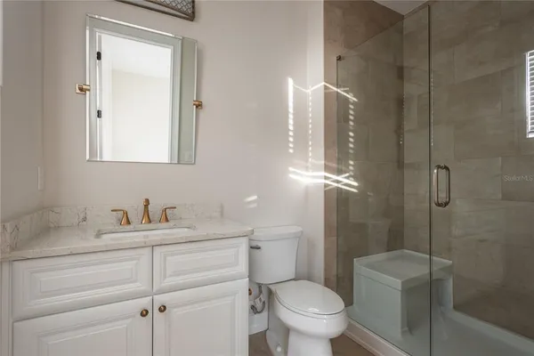 a white toilet next to a bathroom shower