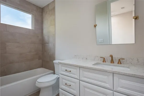 an empty room with wooden floor closet and windows