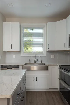 a kitchen with granite countertop white cabinets and a sink