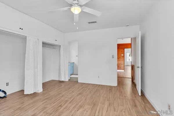 an empty room with wooden floor and door