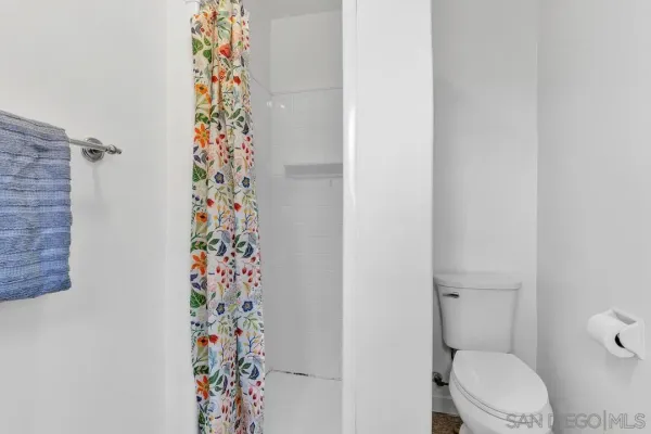 a bathroom with a toilet and a shower curtain