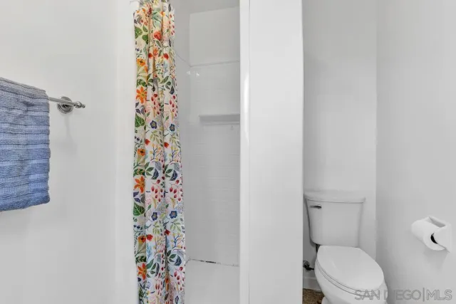 a bathroom with a toilet and a shower curtain