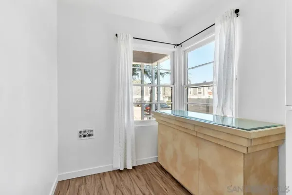 a view of a room that has wooden floor and a window