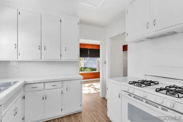 a kitchen with stainless steel appliances a stove a white cabinet and a granite countertops