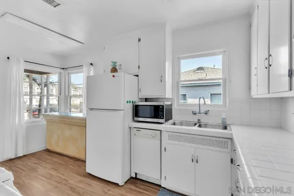 a kitchen with stainless steel appliances a refrigerator sink and microwave