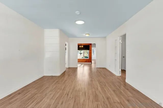a view of a big room with wooden floor and window