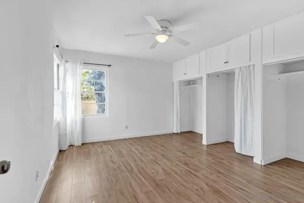 a view of an empty room with wooden floor