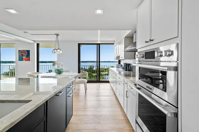 a large kitchen with stainless steel appliances granite countertop lots of counter space and a sink