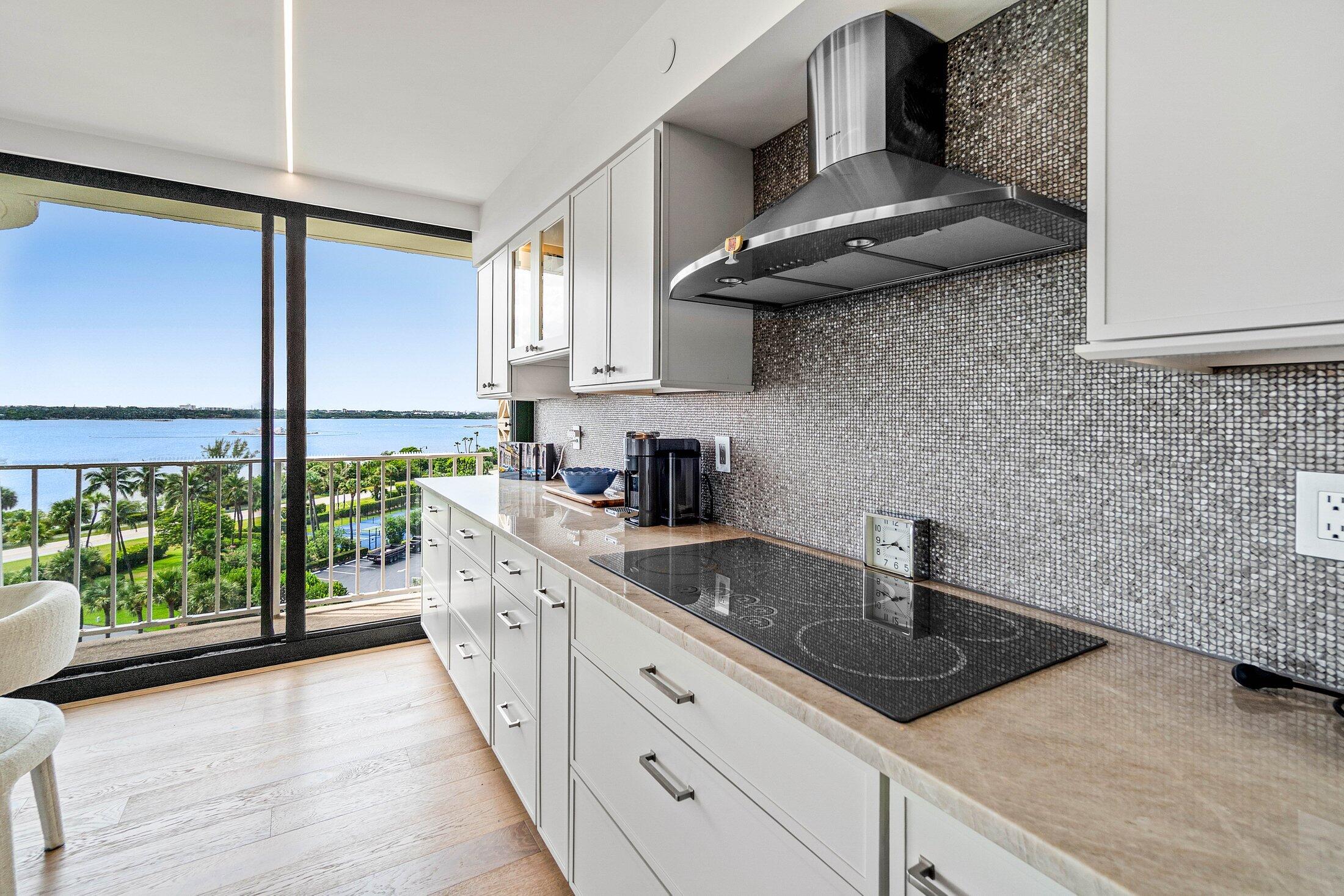 3400 South Ocean Boulevard, Unit 7AII Palm Beach, FL 33480 - Photo 6 of 33 a kitchen with stainless steel appliances granite countertop a sink a stove and a wooden floors
