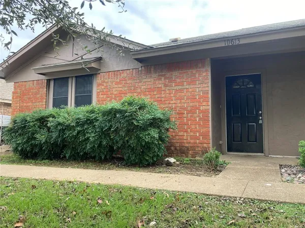 a view of a brick house with potted plants