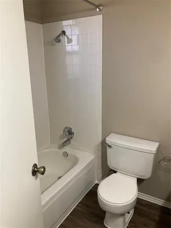 a white toilet sitting next to a bath tub