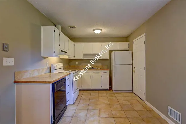 a kitchen with a sink a refrigerator and cabinets