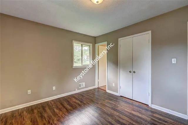 a view of an empty room and window and wooden floor