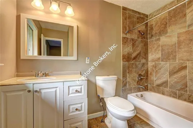 a bathroom with a granite countertop toilet sink and mirror