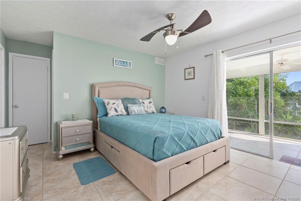 2929 Southeast Ocean Boulevard, Unit 1397 Stuart, FL 34996 - Photo 16 of 38 a bedroom with a large bed and a chandelier