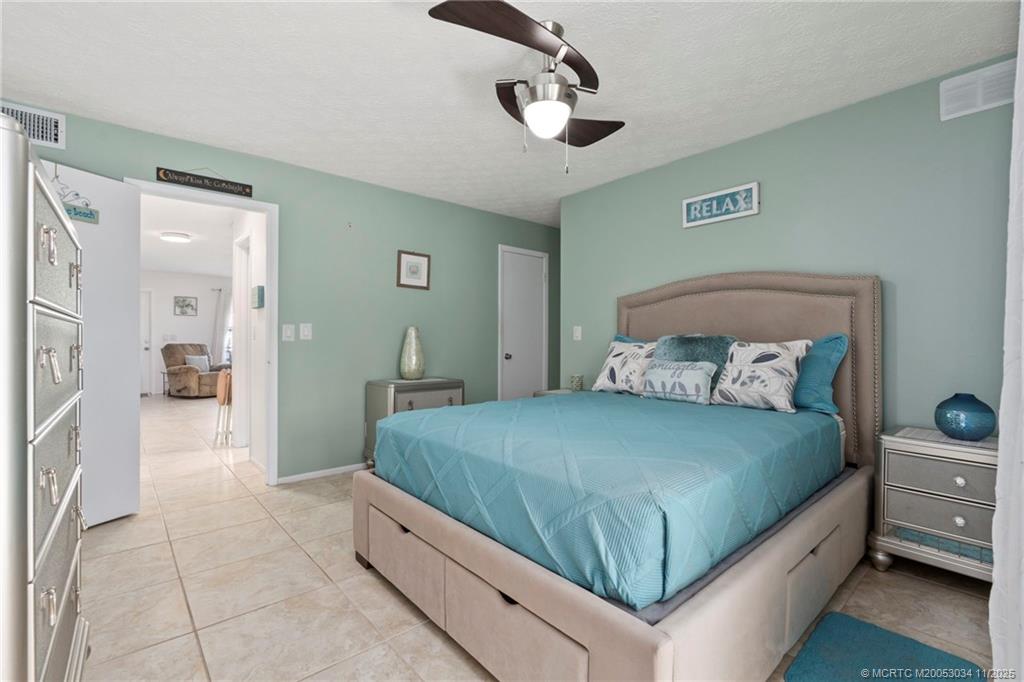 2929 Southeast Ocean Boulevard, Unit 1397 Stuart, FL 34996 - Photo 21 of 38 a bedroom with a large bed and a chandelier