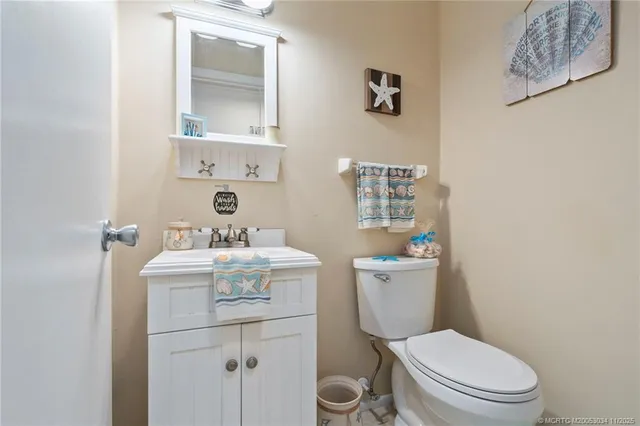 a bathroom with a granite countertop toilet sink and mirror