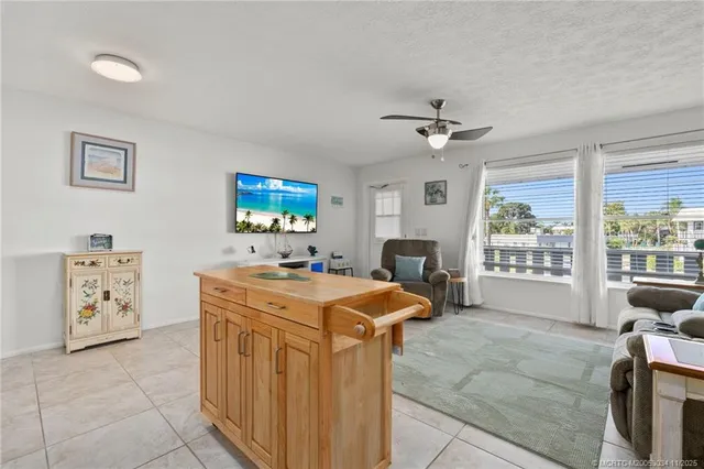 a view of a kitchen with a sink dishwasher a stove and a dining table with bookshelf